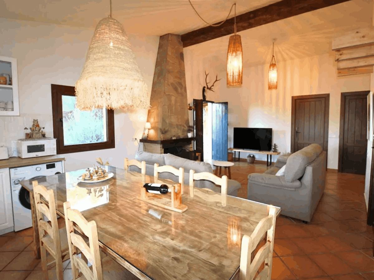 Salón-cocina con mesa de comedor y lámparas de fibra natural
