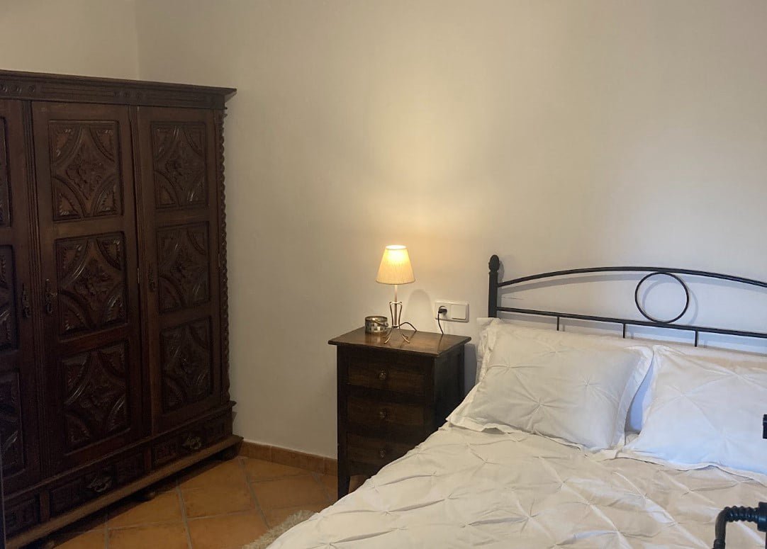 Dormitorio con cama de matrimonio y armario de madera tallada