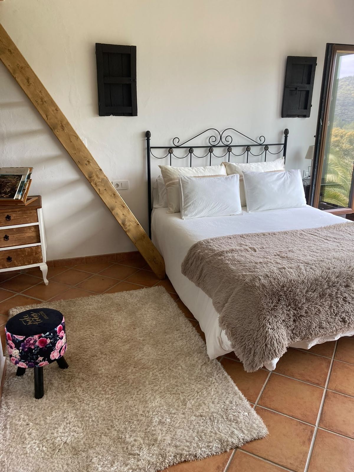 Habitación del ventanal, con cama de matrimonio y el arranque de la escalera del altillo